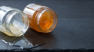 Two tilted jars showing chilled bone broth set into a firm gel while chicken broth stays liquid